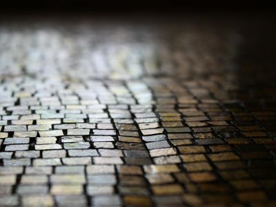 Minimalist yoga bricks on a dark floor surface.